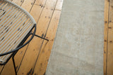 Secured side of a distressed Turkish Oushak runner with subtle beige and platinum patterns.