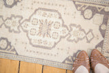 Vintage Oushak rug in pale ivory beige with charcoal geometric spandrel.