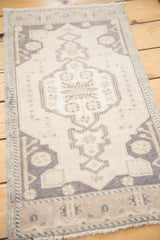 Vintage Oushak rug's scalloped ivory medallion with pearl motif and charcoal geometric spandrels.