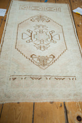 Lower portion of vintage Oushak runner, chocolate brown geometric patterns on antique ivory field with fringe.