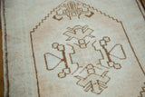 Geometric chocolate brown spandrel contours on pale blush vintage Oushak rug.