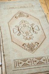 Pale blush, ivory, and brown geometric spandrel contours on a vintage Oushak rug.