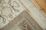 Vintage Oushak rug corner showing geometric brown, blush, green pattern with secured edge.