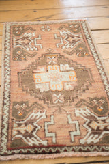 Close-up of Vintage Oushak rug's central stepped medallion and tangerine, bronze, ivory motifs.