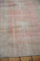 Artfully faded blush and ivory pile texture on a distressed vintage Oushak rug.