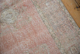 Distressed pile of a vintage Oushak rug, with soft blush, ivory, and platinum tones.