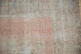 Distressed texture of the blush field and muted ivory patterns on a vintage Oushak rug.
