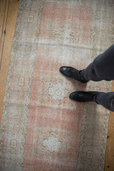 Distressed vintage Oushak runner in blush, ivory, and silver with faded medallions, underfoot.