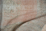 Distressed pile texture of a vintage Turkish Oushak runner, showing blush and ivory tones.