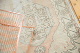 Distressed Oushak runner showing primitive geometric patterns in faded ivory, blush, and charcoal.