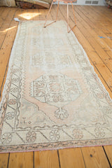 Distressed Oushak runner's oversized primitive medallion in blush, ivory, and silver.