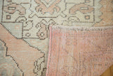 Vintage Distressed Oushak rug showing ivory, blush, and apricot patterns with knotted back.