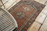 Abrashed copper field of a vintage Oushak rug, showing geometric medallion and serrated border.