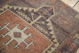 Textured ivory geometric design on abrashed copper field of a vintage Oushak rug.