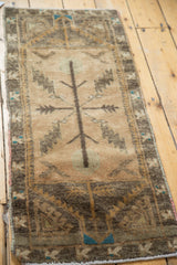Detail of hand-knotted Oushak rug: charcoal tree-of-life with serrated leaves, bronze-turquoise border.