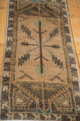 Vintage Oushak runner corner: pale peach apricot field, charcoal serrated leaves, geometric bronze border.