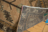 Folded vintage Oushak rug showing its hand-knotted foundation, secured edge, and serrated leaf pattern.