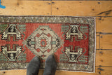 Vintage Oushak rug runner's upper right corner: madder red field, serrated medallion detail, floral border.