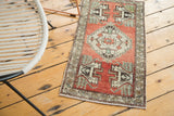 Oushak runner corner with madder root red field, oxidized green motifs, floral border, and fringe.