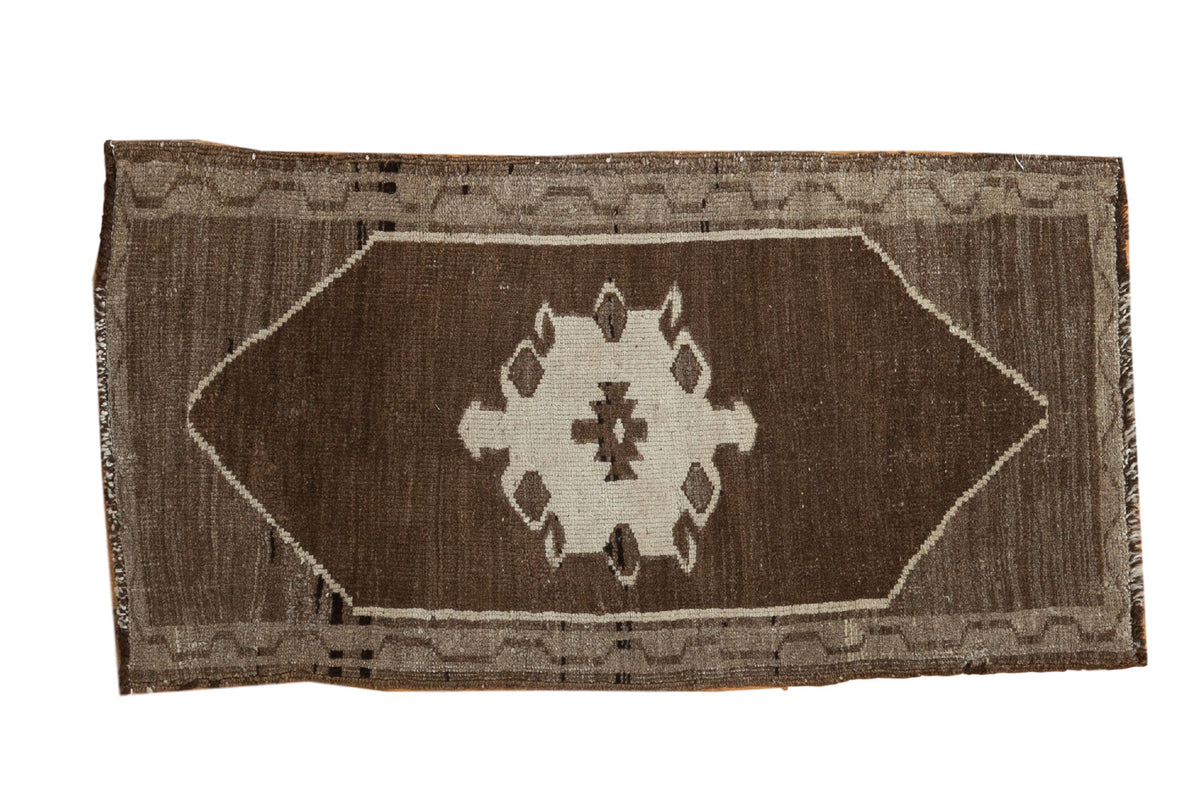 Vintage Oushak runner with an ivory scalloped medallion on a natural un-dyed chocolate brown field, 1'7" x 3'.