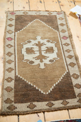 Natural brown tones, geometric stepped diamond border, and even wear on this Oushak rug.