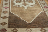Hand-knotted vintage Oushak runner's geometric stepped border in natural ivory, camel, and brown.