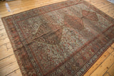 Vintage Shiraz carpet showing distressed pale slate blue field and chestnut brown medallions.