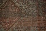 Vintage Shiraz carpet showing distressed pile with exposed knot heads and muted patterns.