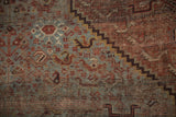 Vintage Shiraz carpet detail: pale blue field, bird and plant motifs, chestnut tones, and visible knot heads.