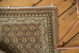 Distressed vintage Turkish Sivas rug corner, showing blush mir boteh motifs and pale borders.