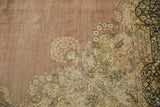 Distressed vintage Kerman rug, pale blush field with visible foundation and intricate curvilinear floral motifs.