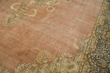 Distressed Kerman carpet with traditional blossoming floral spandrels and navy border.