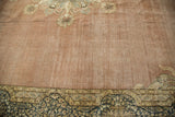 Distressed vintage Kerman carpet, pale blush field, and intricate navy floral border.