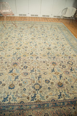 Distressed North West Persian carpet's traditional repeating pattern in ivory, navy, rose, saffron.