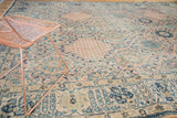 Vintage Kashan rug with ornate blue floral motifs and scrolling vinery on a blush field.