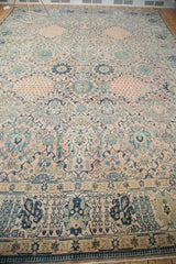 Ornate border with dark blue floral motifs, intricate scrolling vinery on the blush Kashan field.