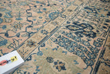 Vintage Kashan carpet displaying blush field, intricate blue floral motifs, and panel design.