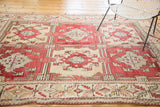 Vintage Oushak carpet with cherry red geometric floral and quatrefoil leaf designs.