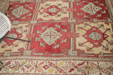 Vintage Oushak rug's cherry red geometric floral panels and intricate patterned border.