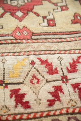 Vintage Oushak rug pile with cherry red quatrefoil and pale saffron yellow motifs.