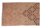 Vintage Turkish Jijim carpet with geometric lattice panels in faded red, antique ivory, and dark brown.