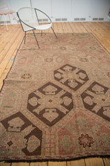 Chocolate brown geometric panels and striped linear texture on a vintage Jijim carpet.