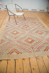 Fringed edge of a vintage Turkish Jijim rug with ivory, red, yellow diamond pattern.