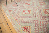 Woven texture of repeating aubergine, red, saffron diamond motifs on the vintage Jijim.