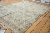Vintage distressed Jijim rug corner showing geometric silver and charcoal border and fringe.