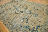 Distressed Tabriz carpet with faded indigo and powder blue floral motifs, visible texture.