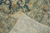 Hand-knotted backing revealed on a distressed Tabriz carpet, with faded indigo floral design.