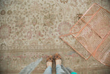 Distressed Tabriz carpet texture with faint Kerman vase motifs in blush and ivory.
