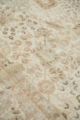 Distressed Tabriz carpet pile showing subtle ivory, blush, and silver botanical motifs.