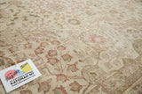 Distressed Tabriz carpet featuring ivory, blush, and rose tones with intricate vintage motifs.